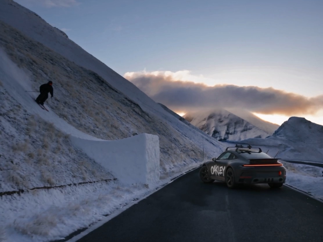 Porsche con gráfica Oakley en una carretera de montaña nevada